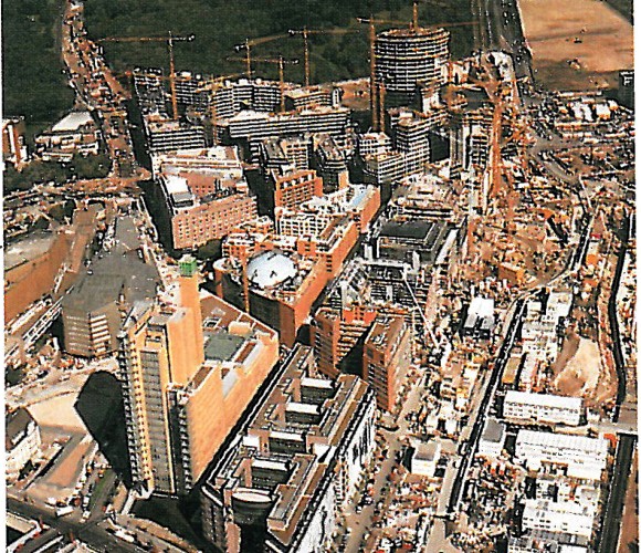 Aerial view of the Daimler-Benz site during construction, with cranes and unfinished towers