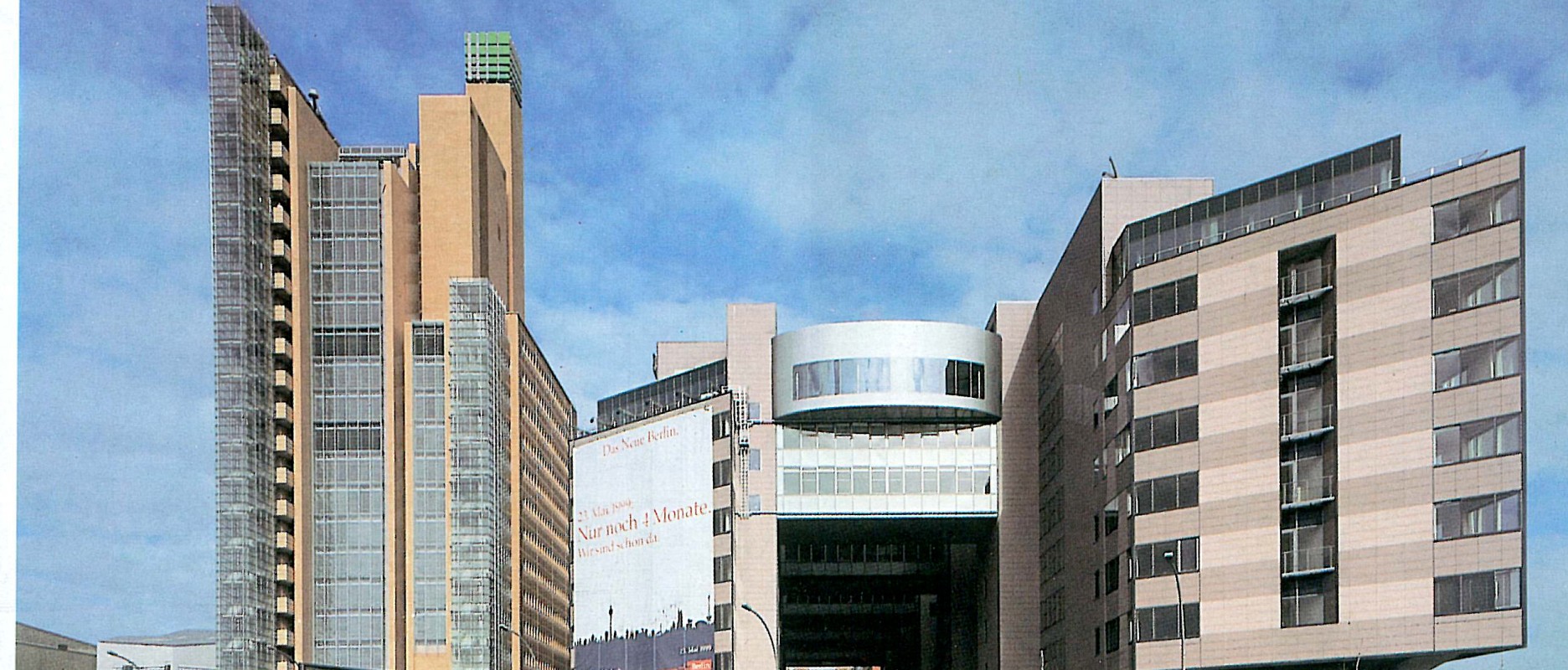 Panorama of the plaza with construction-period billboards along the building fronts