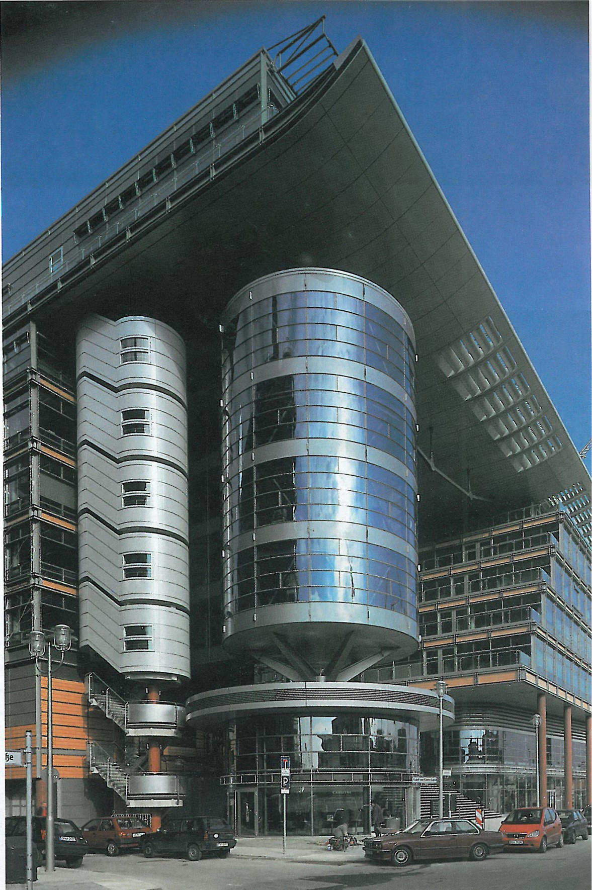 Curved glass-and-steel facade of one of the Kollhoff buildings, seen from below
