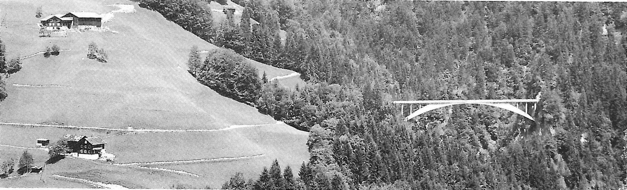A Maillart concrete arch bridge crossing an Alpine valley
