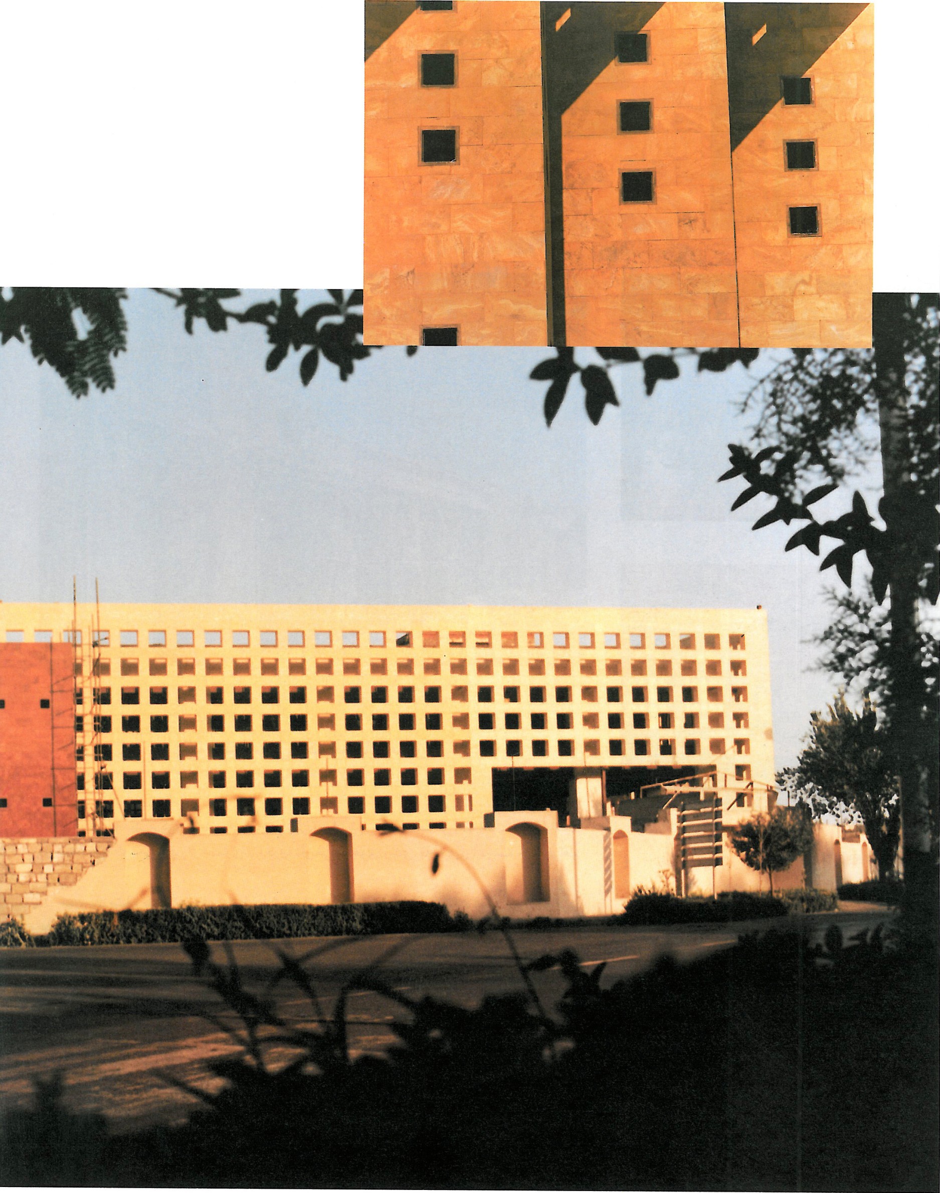 Wide view of the Esfahan Library: a large red-brick rectangular building with a finely netted brick perforation pattern set against the dark silhouette of overhanging trees.