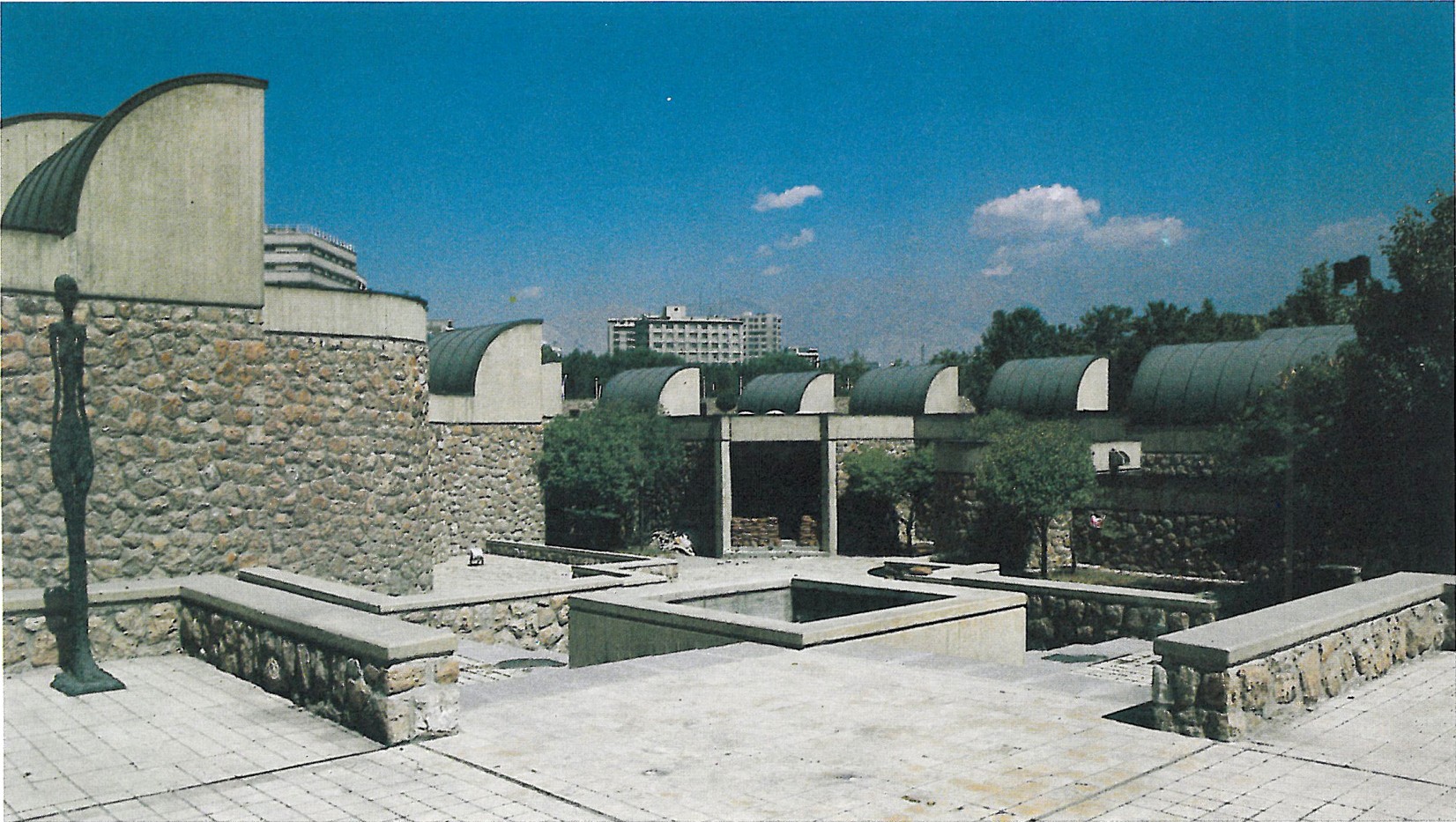 Tehran Museum of Contemporary Art exterior view showing the curved vault skylights, sculpture garden and stone walls