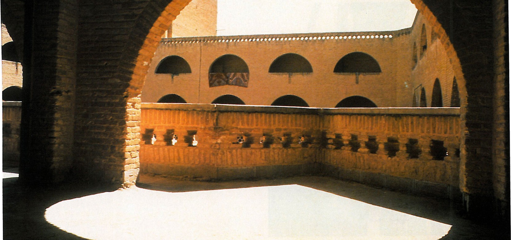 Brick vaulted gallery of the apartment building set above the neighborhood plaza at Shushtar