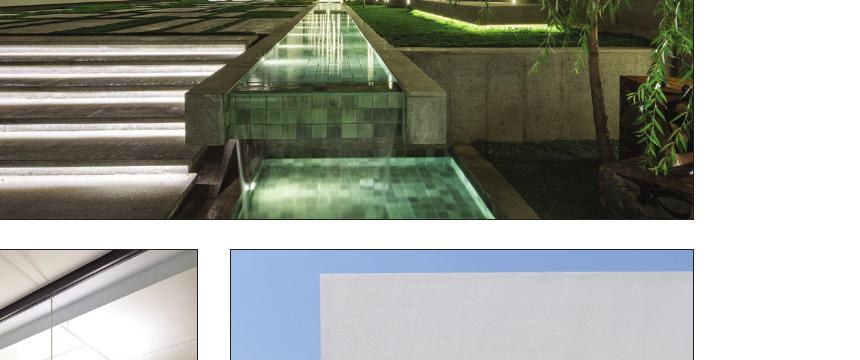 Night view of Dove Residential pool with the green-tinted pool surrounded by the white volume