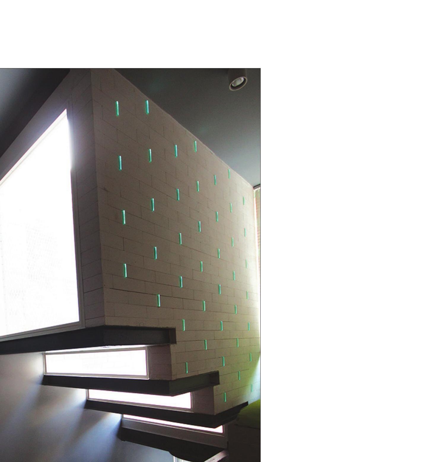 Cantilevered black stair tread of the House of Deflection with a graphic illuminated edge