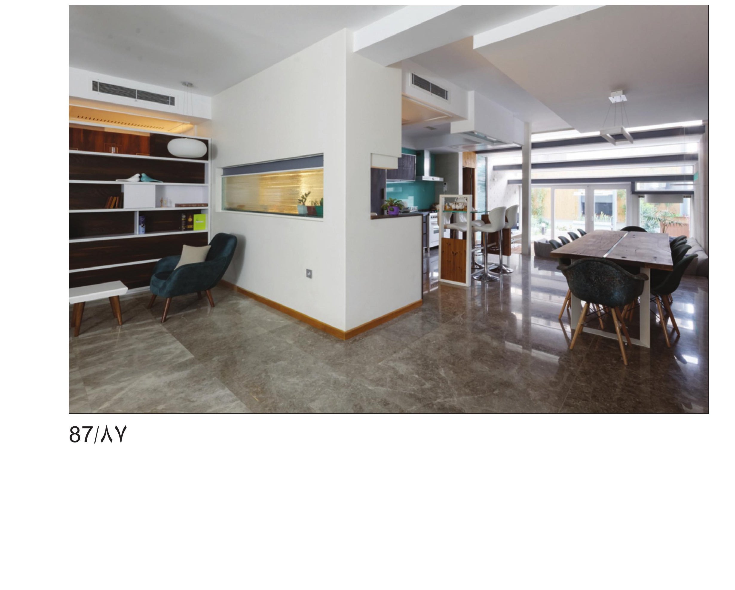 Interior living and dining space of the House of Deflection with exposed concrete columns