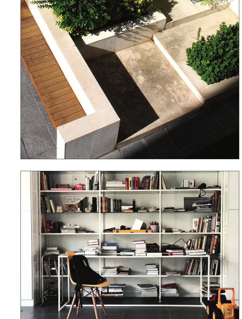 Manzarieh interior — open second-floor living area with bookshelves, a study desk and a black chair