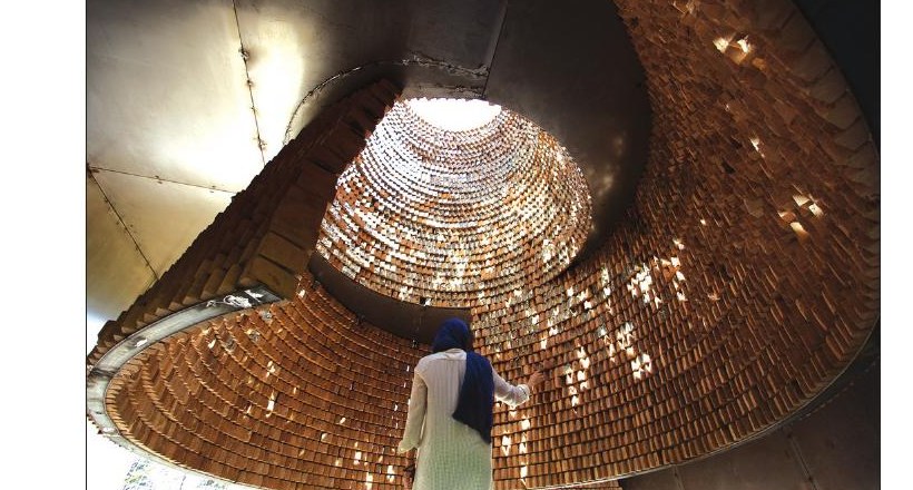 View up into the brick spiral cone interior of the Pause Pavilion with light entering from above