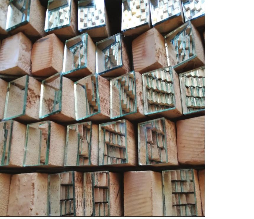 Closeup of the brick wall showing inserted mirror fragments within the brickwork