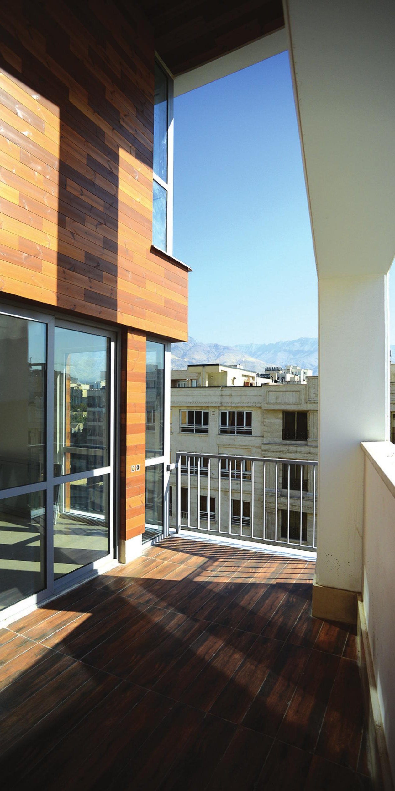 Wood-clad lobby interior with travertine floor banded in white stone