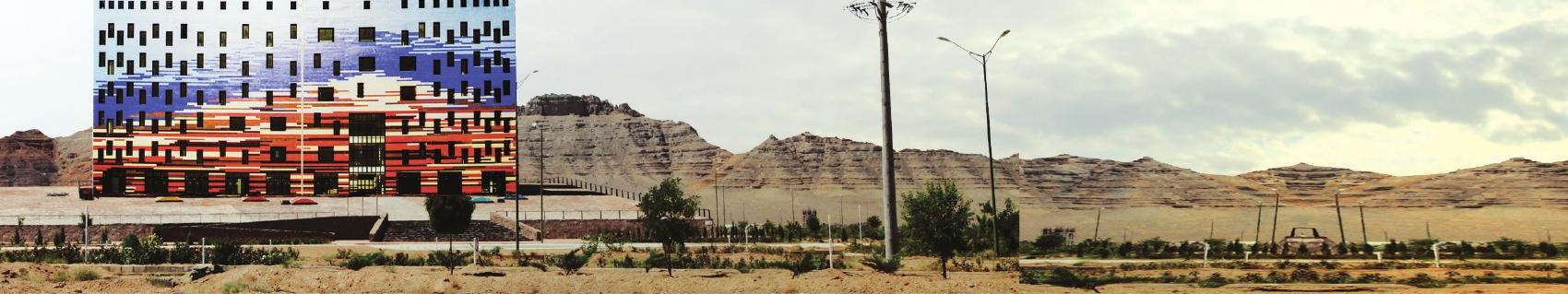 The Science and Technology Growth Center seen from a distance set in the desert with mountains behind