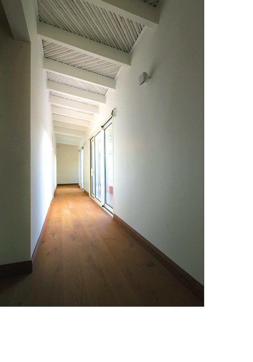 Interior corridor of White House 1 with bamboo ceiling and full-height glazed wall to the garden