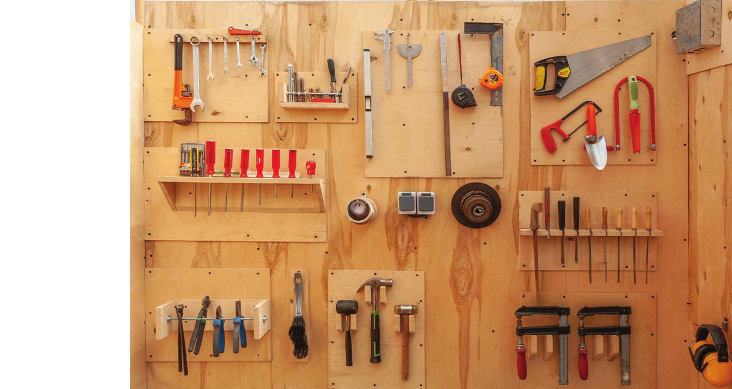 دیوارِ ابزارِ کارگاه: تخته‌ای تخته‌سوار با چکش‌ها، اسکنه‌ها، اره‌ها، گیره‌ها و خط‌کش‌ها در ردیف ـــ بسترِ عملیِ همان فرآیندِ آزمون و خطایی که معماران از آن می‌گویند.