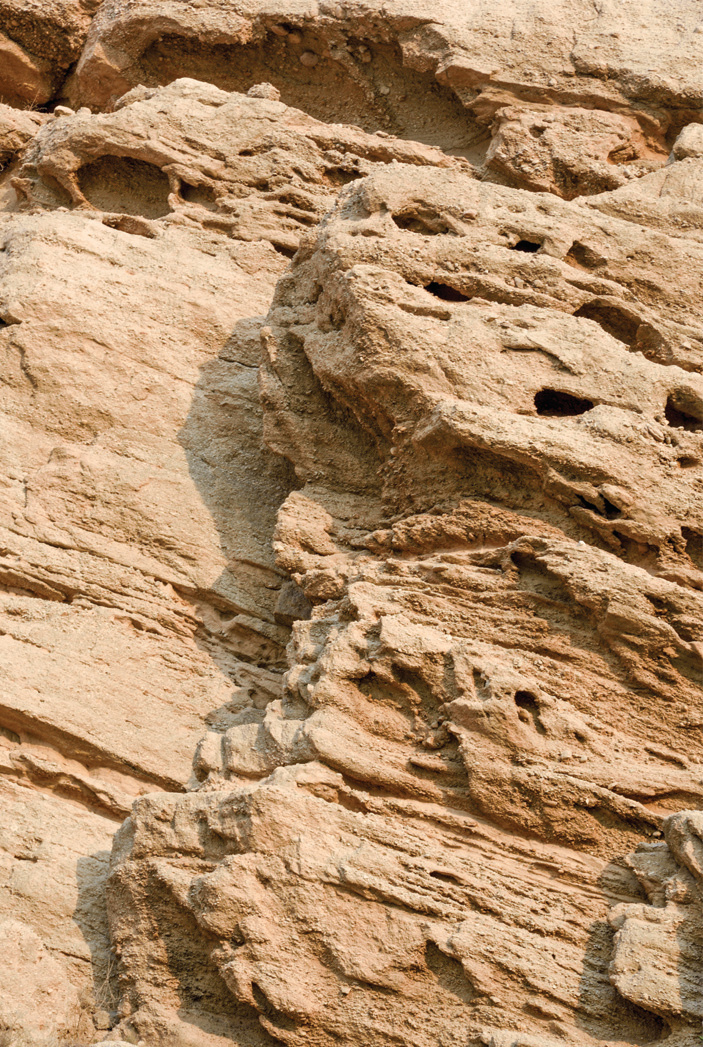 Close-up of eroded sedimentary rock formations at the entrance gorge of Siraf, sculpted by millennia of natural forces