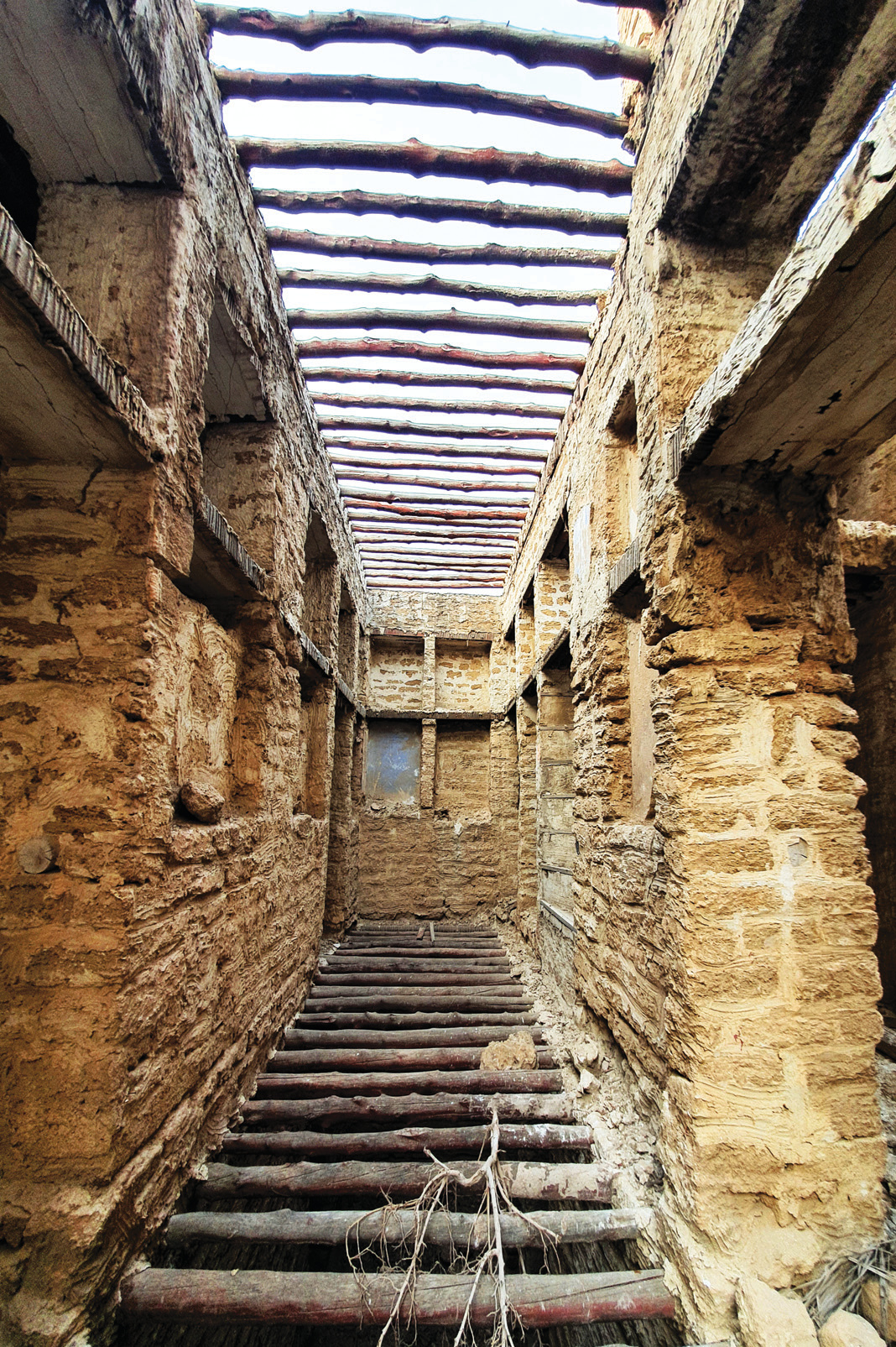 Exposed chandel wood beams and coral stone walls during restoration