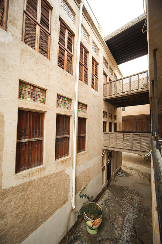 Exterior alley view showing four stories with stained glass and wooden windows