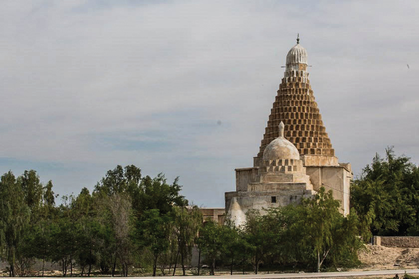 Distant view of the shrine of Mir Mohammad Hanifeh rising above green trees on Khark Island