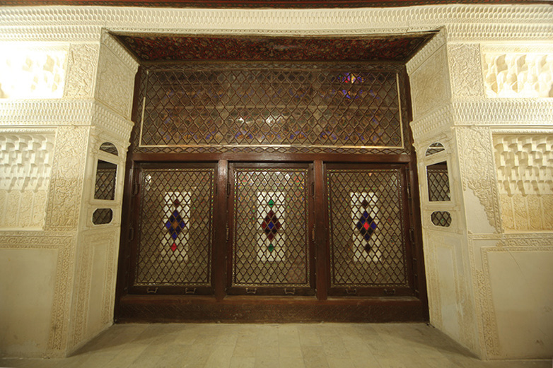 Large orosi panel with intricate lattice work, stained glass diamonds, and plaster molding