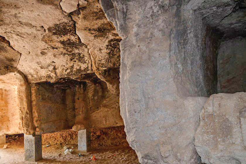 Interior of the Palmyran tomb showing the stone ceiling and carved walls