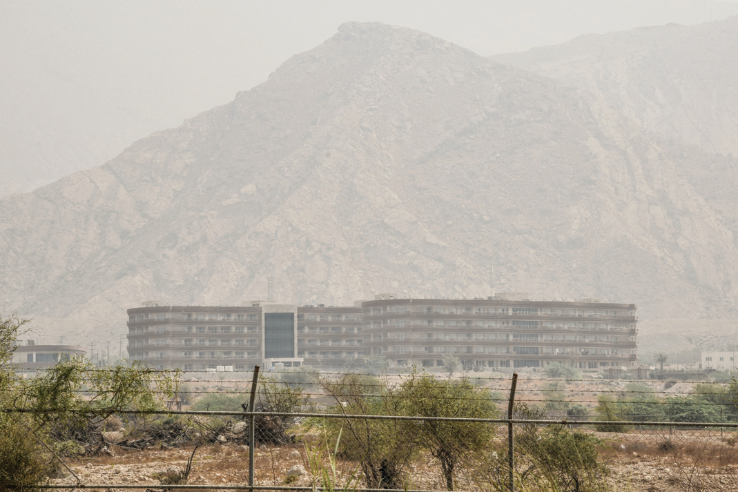 A residential complex within an industrial site, mountains barely visible through the polluted haze