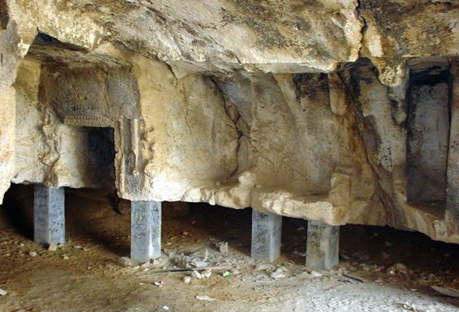 Interior of a rock-cut chamber with concrete support columns added for structural reinforcement