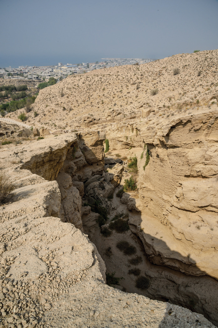 Panoramic view of Siraf from the heights of the Lir Valley, looking down through a rocky gorge to the sea and town beyond