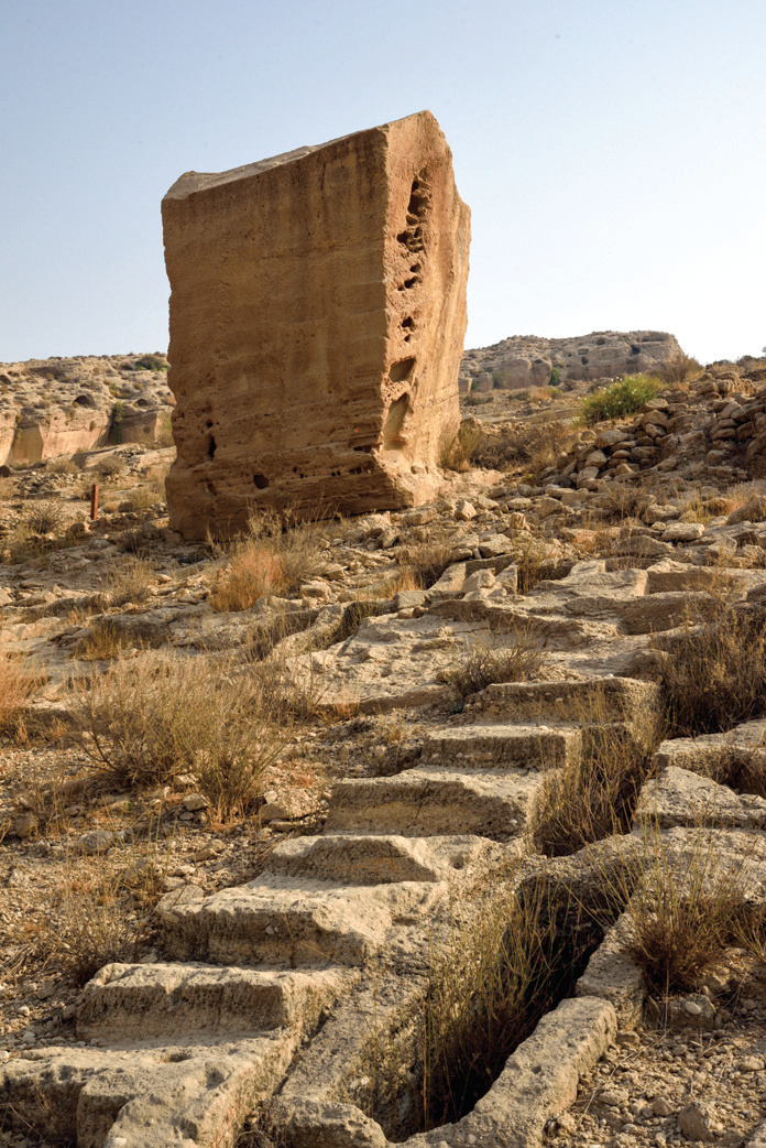 Rows of rectangular stone graves cut into the rock leading toward the ossuary in the Lir Valley