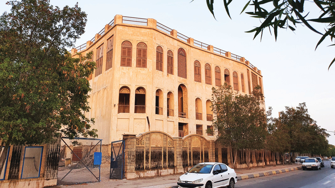 Haj Raeis Edifice rising above the port authority walls, viewed from the street
