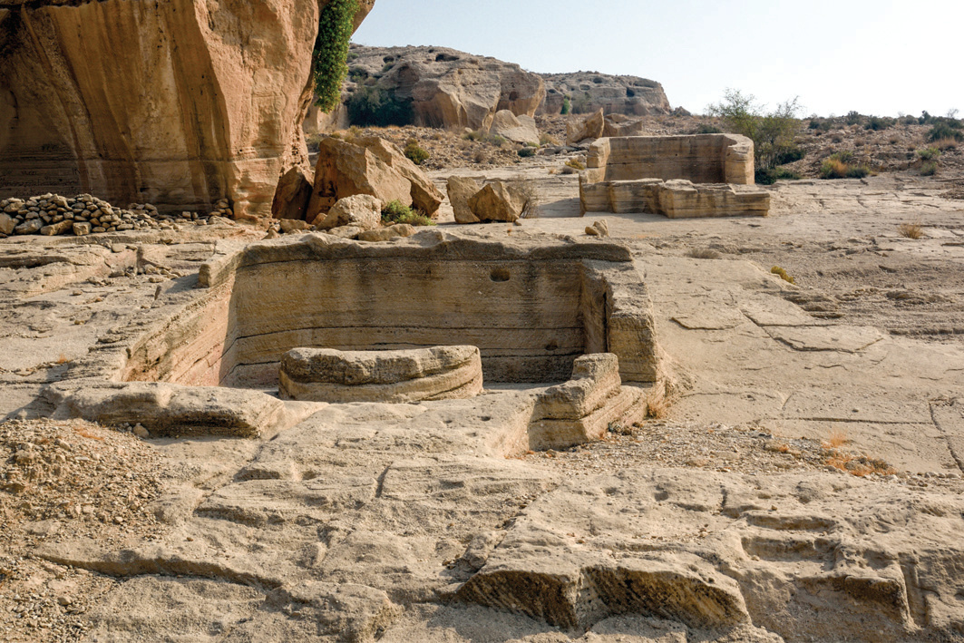 Close-up of wells carved into the rock surface in the Lir Valley, showing stone rings and channels