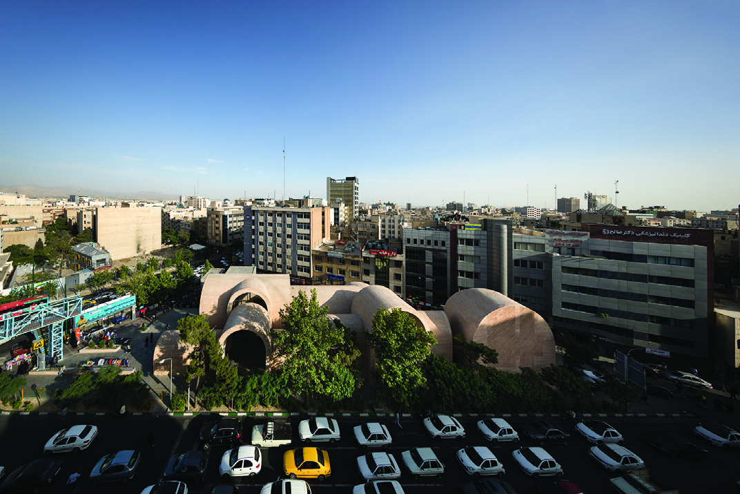 Aerial view of the vaulted brick structure showing the undulating roofscape of interconnected arches creating a labyrinthine canopy over the plaza