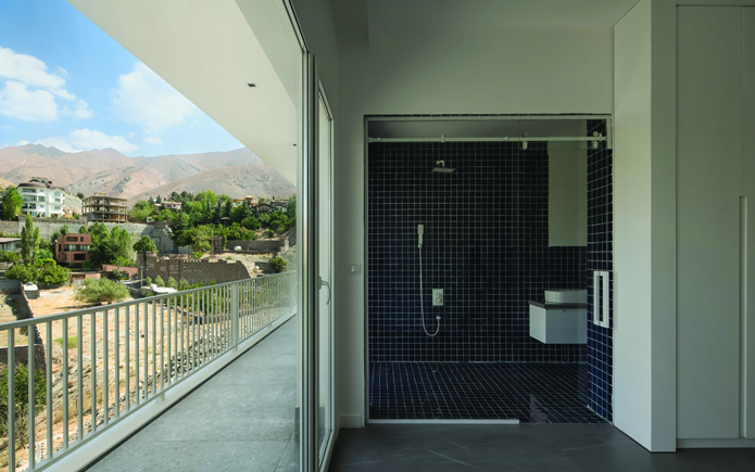 Bathroom opening onto a private balcony with mountain views