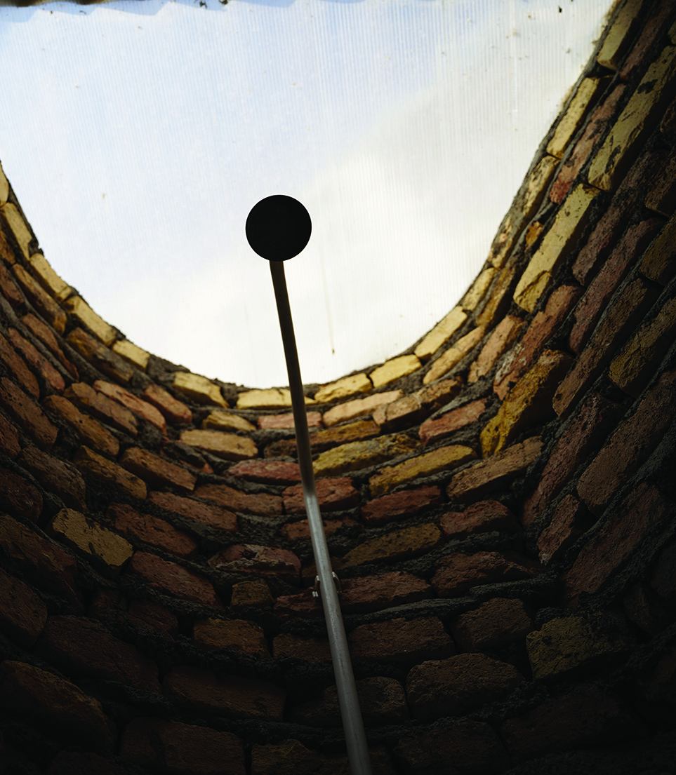 Interior of the curved brick bathroom with arched ceiling and a small skylight