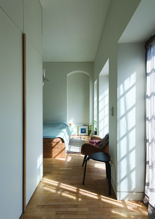 Bedroom with an arched alcove, minimal furnishing, and soft natural light