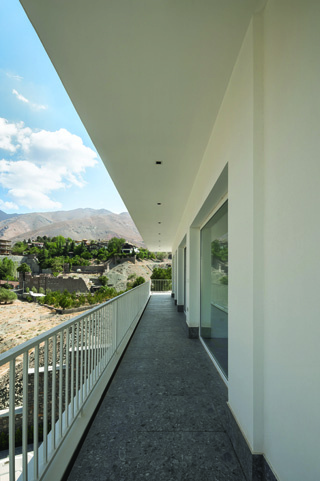 Corridor opening onto a balcony with mountain views to the north