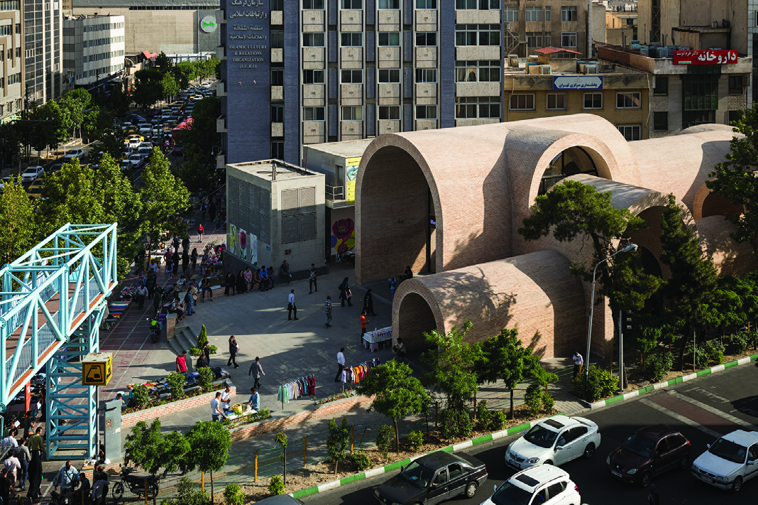Elevated view showing the full extent of the vaulted brick structure with multiple arches of varying sizes, the pedestrian bridge on the left, and the dense urban fabric beyond