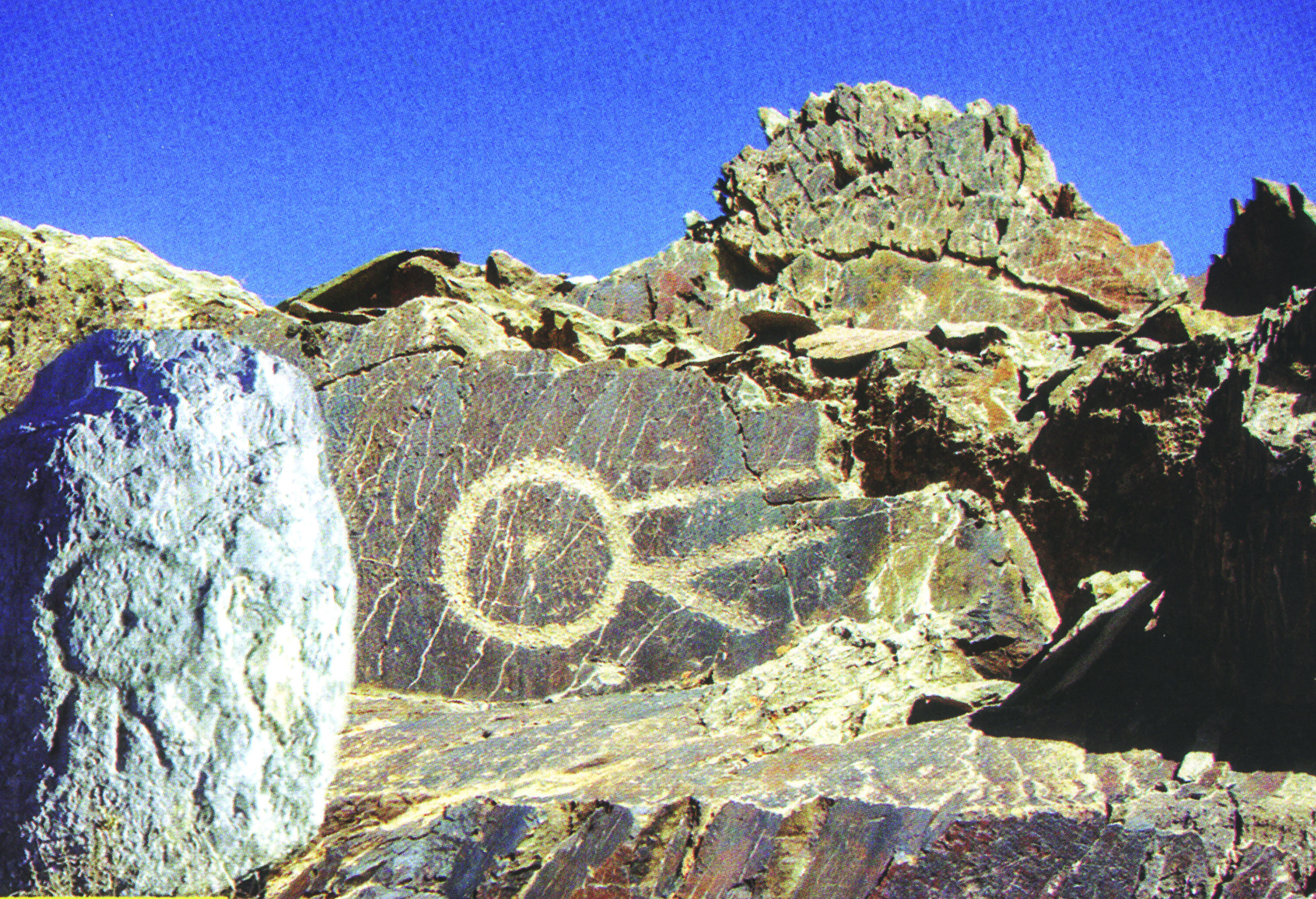 Stylised geometric ibex petroglyphs on a large boulder at Baghbadaran, Isfahan, alongside a circular symbol