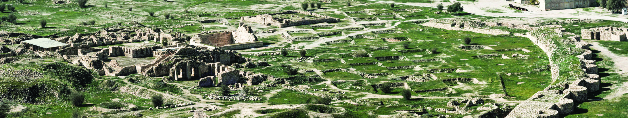 Panoramic view of the Bishapur archaeological site showing ancient ruins spread across a green valley