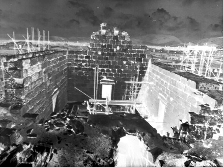 Archival black-and-white photograph showing an elevated view of the Anahita temple at Bishapur with scaffolding