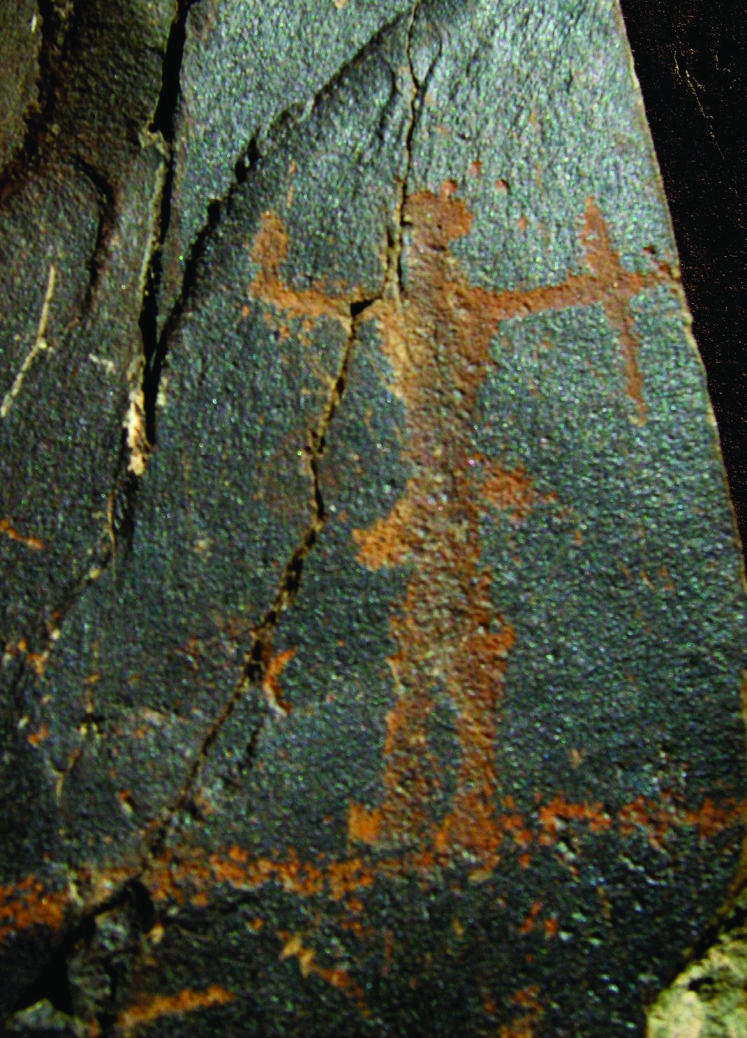 A standing human figure petroglyph at Darreh Negaran with ochre colouring on dark rock