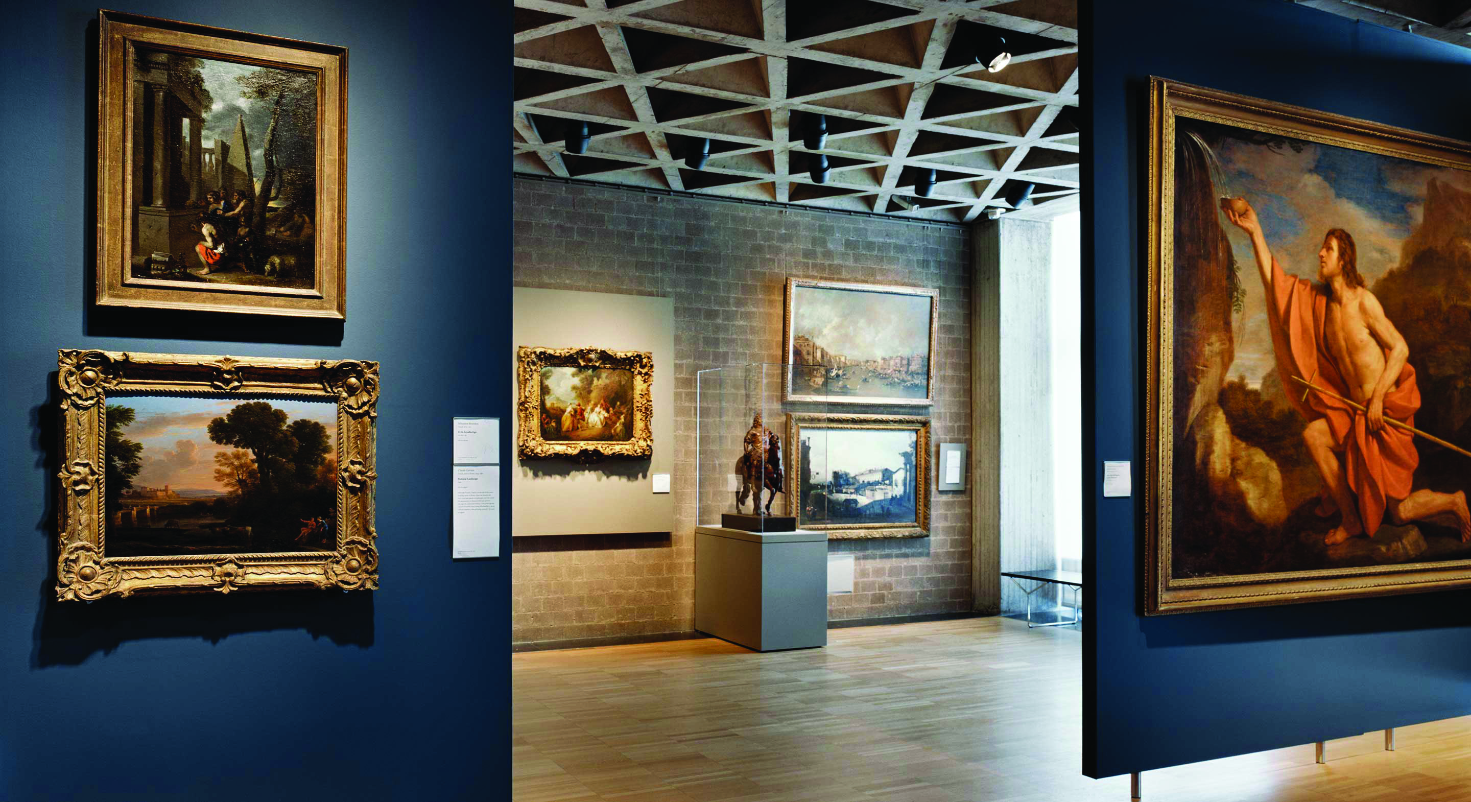 Color photograph of a gallery room in the Yale Art Gallery displaying European paintings in ornate frames on white walls beneath the tetrahedral ceiling