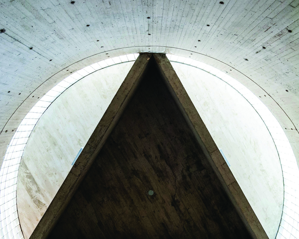 Color close-up photograph of the concrete triangle in the Yale Art Gallery stair drum, showing the rough concrete texture and dramatic natural light