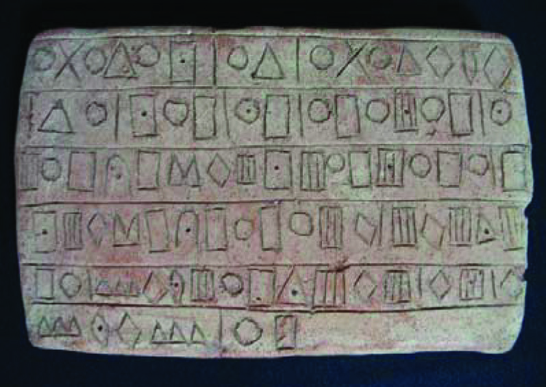 Ancient inscribed tablet from Jiroft displaying rows of geometric symbols that may represent a form of early writing or alphabet