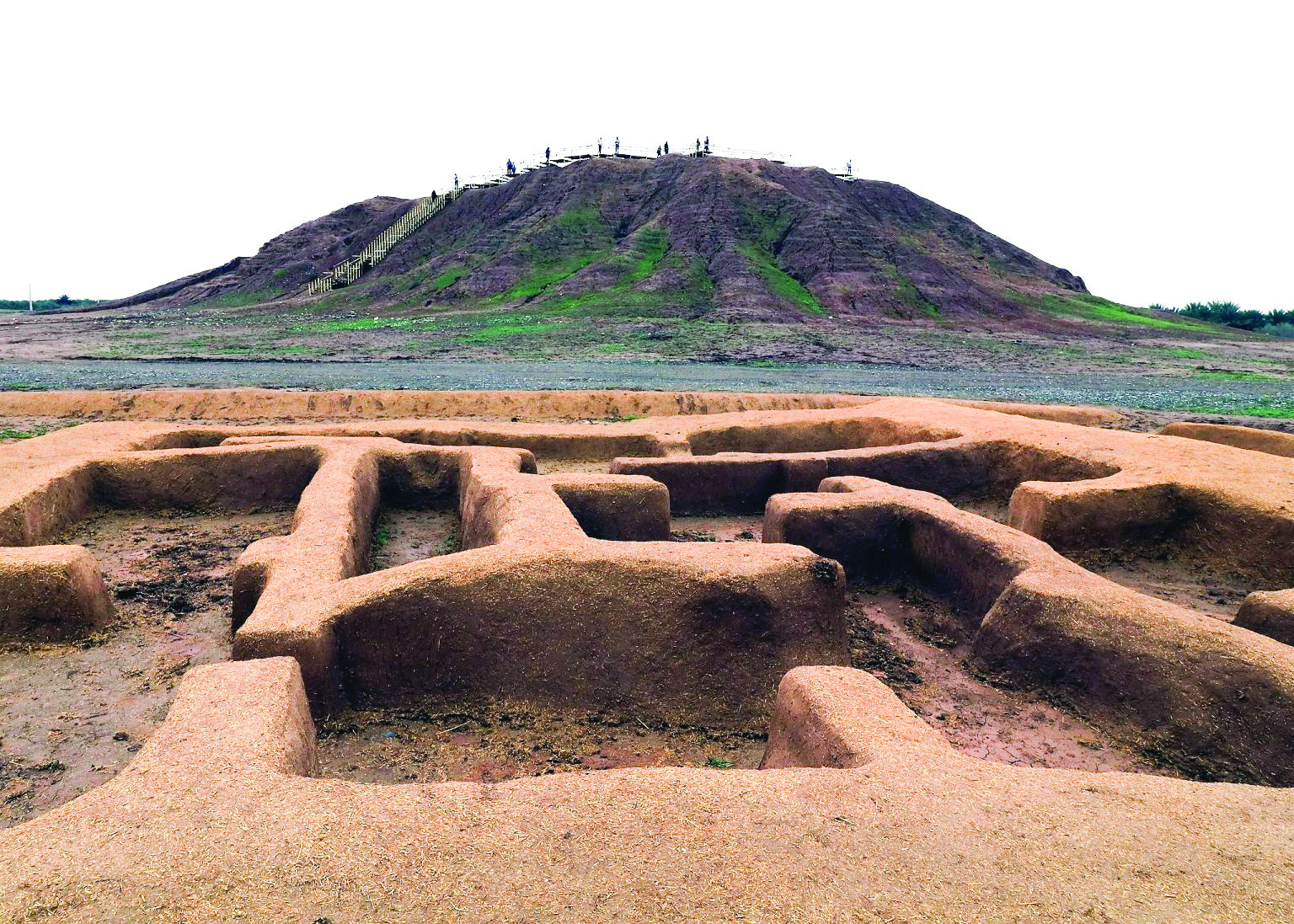 View of Tappeh Konar Sandal in Jiroft with excavated mud-brick structures in the foreground and the main mound rising in the background