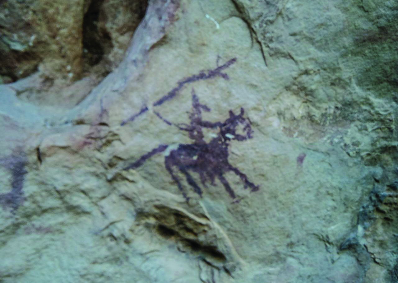 Painted figure of a hunter on horseback wielding a spear, rendered in dark purple-red ochre on sandstone in Lorestan