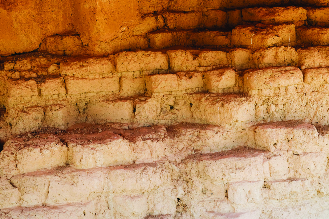 Close-up view of ancient mudbrick wall construction showing layered sun-dried adobe bricks in warm ochre and terracotta tones