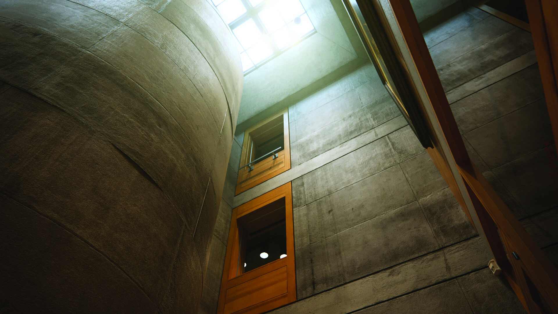 Color photograph looking up at the stair drum interior, showing the atmospheric concrete walls and the glass block ceiling through which natural light enters from above