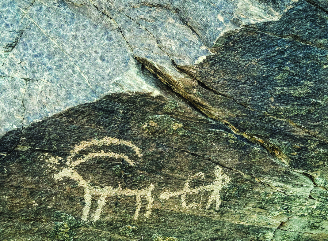 Teimareh petroglyph showing a large ibex with a smaller ibex kid beside it on blue-grey rock