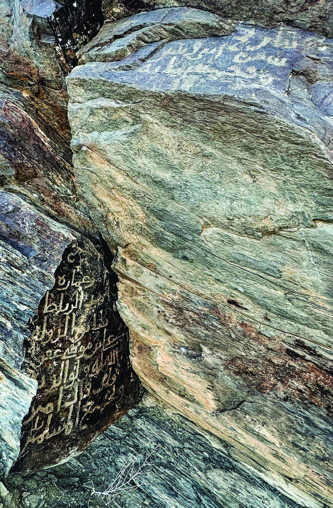 Ancient petroglyphs at Teimareh defaced by modern Arabic-script graffiti scratched into the rock surface