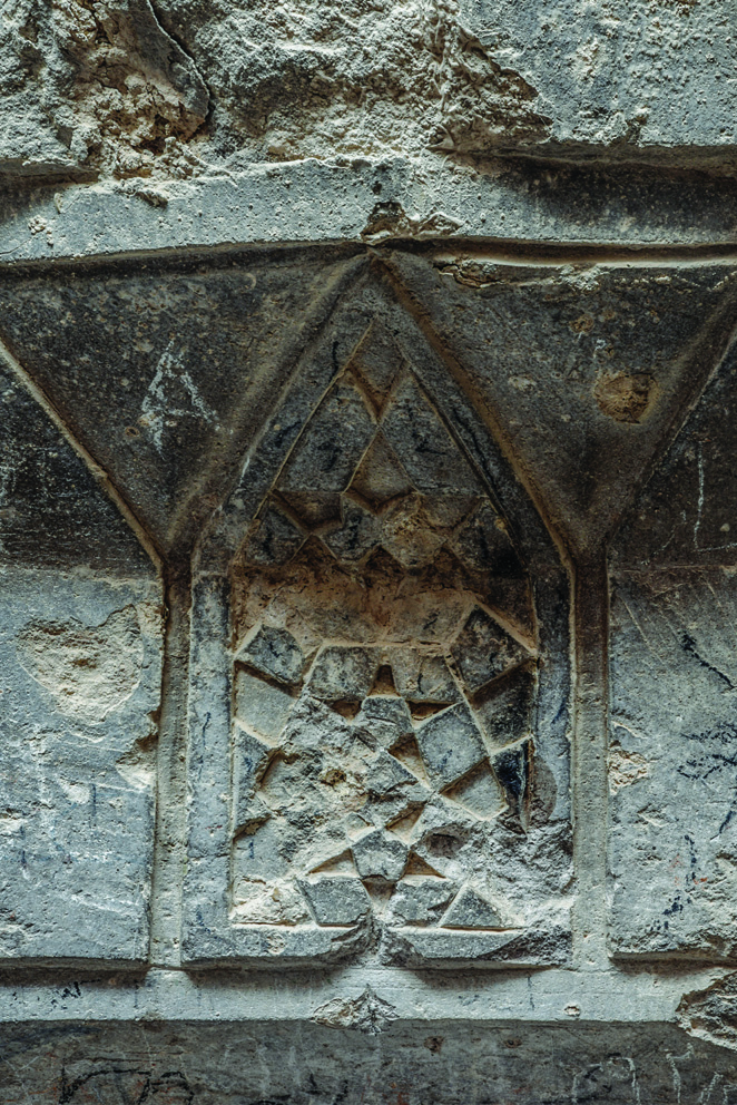 Close-up of geometric stone carvings on the dome drum of the sanctum in the Varjovi Mithraeum, showing Ilkhanid-era patterns