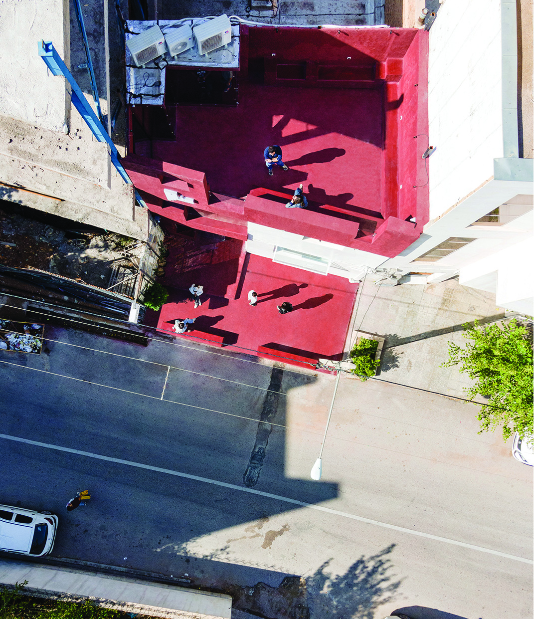 Aerial view of Journey Cafe showing the red cement rooftop with people sitting on the stepped staircase structure, the street and pavement visible below